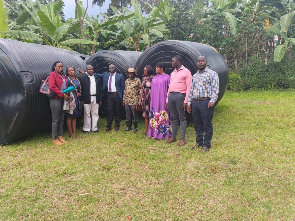 District Officials and AAH Staff distribute 10,000 liter water tanks